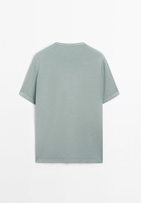 Light green short-sleeve t-shirt made of soft fabric. Round neckline with a straight cut and minimal stitching detail on edges.