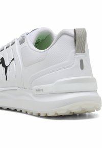 Vit sportig sneakersko med nät- och syntetmaterial. Har ett texturerat mönster, grå accenter och en logotyp. Tjock vit sula med grepp.