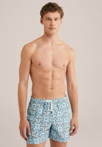 Peldbikses ar gaiši zilu pamatniņu, kurām ir daudzkrāsains spalvu raksts, elastīga jostasvieta un balta aukla. Izgatavotas no kokvilnas materiāla.