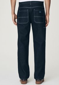 Donkerdenim jeans met een recht model, contrasterende lichte stiksels, twee achterzakken en een zijvak voor gereedschap.