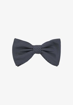 Noeud papillon bleu marine avec un motif texturé de petits carrés blancs. Le tissu semble tissé et légèrement structuré, avec un nœud centré.