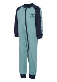 En overallpyjamas med dragkedja i ljus teal med mörkblå ärmar och muddar. Har logotyp på bröstet och mönstrad detaljering på ärmarna. Mjuk textur.