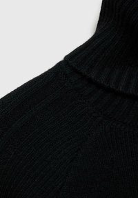 Pull en col roulé noir avec une texture côtelée, mettant en avant un col haut et un motif en tricot diagonal. Tissu doux et chaud ; vue en gros plan.
