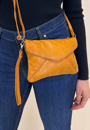 Sac en cuir orange à bandoulière avec fermeture à rabat, présentant une finition texturée, une sangle ajustable et un détail de porte-monnaie.