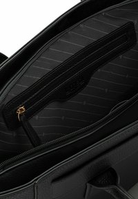 Schwarze Lederhandtasche mit strukturiertem Futter, ausgestattet mit einem Reißverschlussfach und einem zusätzlichen Einschubfach zur Organisation.