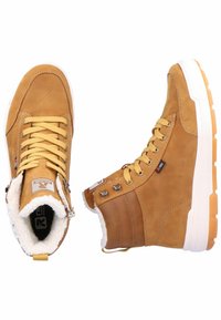 Braune Lederknöchelstiefel mit einer gepolsterten weißen Fellfutter, gelben Schnürsenkeln und einer weißen Gummisohle mit strukturiertem Muster.
