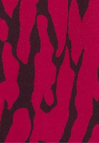 Motivo astratto con forme nere irregolari su uno sfondo rosso vivace, che ricorda una stampa animale o forme organiche.
