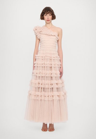 Eén-schouder lange jurk van zacht roze tule, gelaagd met ruffles en stippen. Getailleerde korsage, vloeiende rok en subtiele textuur door het geheel.