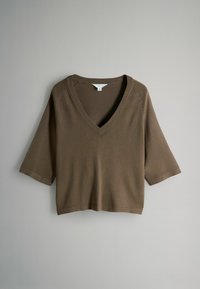 Brauner, kurzärmeliger Pullover mit V-Ausschnitt und lockerem Schnitt. Hergestellt aus einem weichen, strukturierten Stoff, der an den Kanten einfache Nähte aufweist.