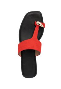 Red suede flat sandal with a black sole, featuring a wide strap and a metallic buckle accent. The design has an open toe and back.