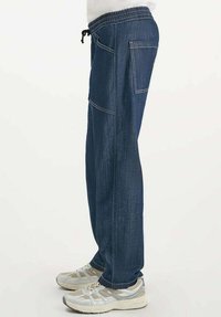 Donkerblauwe denim joggers met een elastische tailleband en trekkoord, zijzak en een losse pasvorm voor comfort.