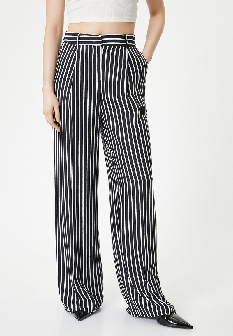 Zwart-wit gestreepte wijde broek met hoge taille, voorzien van riemlussen, zijzakken en een gladde stofstructuur.