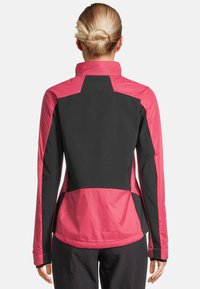 Zwarte en roze jas met een hoge kraag, een nauwsluitend ontwerp en contrasterende panelen. Vaste textuur met elastische manchetten en zoom.