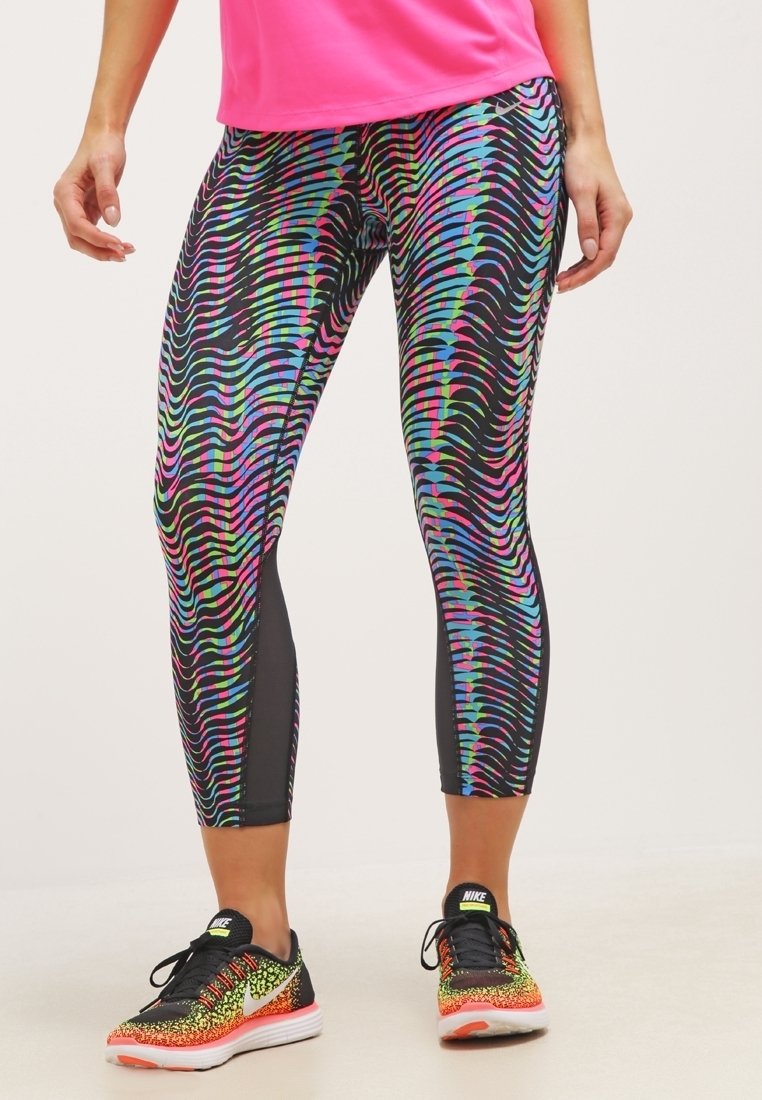 Leggings colorés et à motifs avec une base noire et des rayures ondulées en rose, bleu et vert ; fabriqués en matériau extensible et respirant.