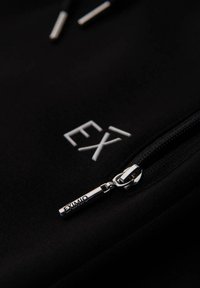 Czarna bluza z kapturem z zapięciem na zamek błyskawiczny i metalowymi elementami, haftowanym białym logo "EX'1" oraz miękką, gładką fakturą materiału.