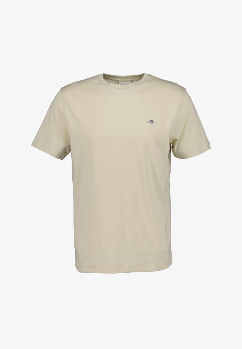 T-shirt beige à manches courtes avec col rond, petit emblème brodé sur la poitrine gauche, devant uni et coupe régulière.