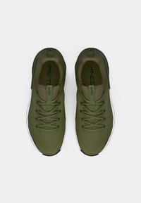Olive green athletic shoes with a textured fabric upper, lace closure, and a white midsole. Features a black outsole and branding on the tongue.
