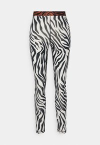 Leggings con motivo zebra caratterizzati da un design bianco e nero con una cintura a righe marrone, realizzati in un materiale elastico e liscio.