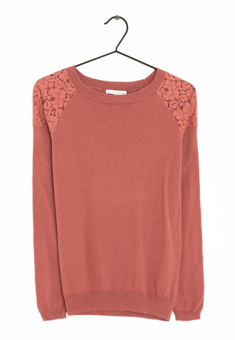 Maglione a maniche lunghe color ruggine con pannelli di pizzo floreale sulle spalle appeso a una gruccia nera su uno sfondo bianco.