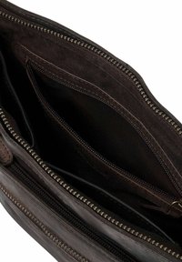 Intérieur d'un sac en cuir marron avec plusieurs compartiments, présentant des surfaces lisses et texturées, ainsi que des détails en métal sur la fermeture éclair.