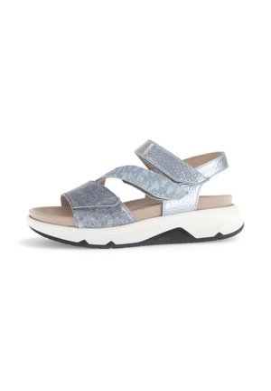 Zilveren platformsandalen met gekruiste banden, voorzien van een gestructureerde bovenkant, een zachte inlegzool en een contrasterende zwarte buitenzool.