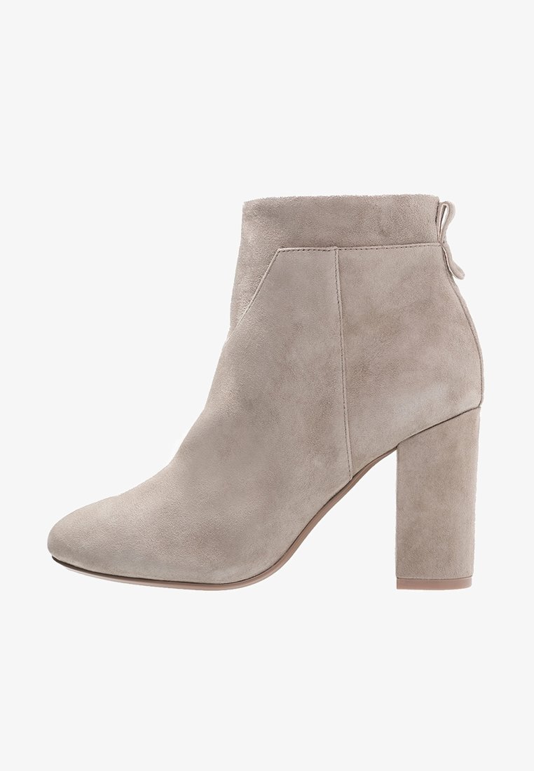 Stivale alla caviglia in suede grigio con punta appuntita, dettaglio cucitura laterale e tacco a blocco spesso. La parte superiore ha una texture liscia e una linguetta sul retro.