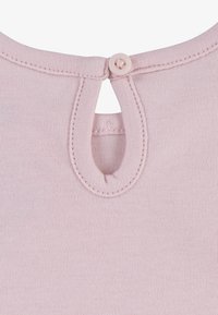 Svijetlo ružičasta tkanina s mekom teksturom, s okruglim izrezom i malim otvorom na leđima učvršćenim dugmetom.