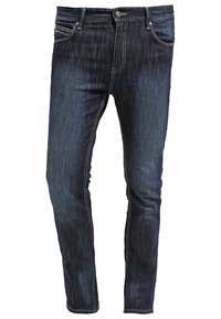 Vaqueros ajustados de azul oscuro con cinco bolsillos, cierre de botón y cremallera, y costuras visibles blancas.