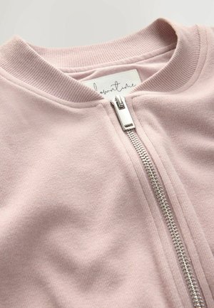 Helle rosa Zip-Jacke mit geripptem Kragen und silbernem Reißverschluss, aus weichem Stoff mit glatter Textur und dezentem Glanz.