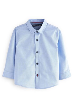 Chemise bleu clair à manches longues pour tout-petit avec col et fermeture à boutons sur le devant, comprenant un bouton rouge près du bas.