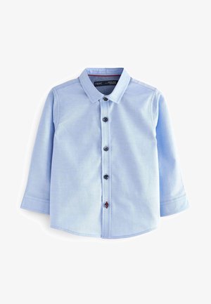 Chemise bleu clair à manches longues pour tout-petit avec col et fermeture à boutons sur le devant, comprenant un bouton rouge près du bas.