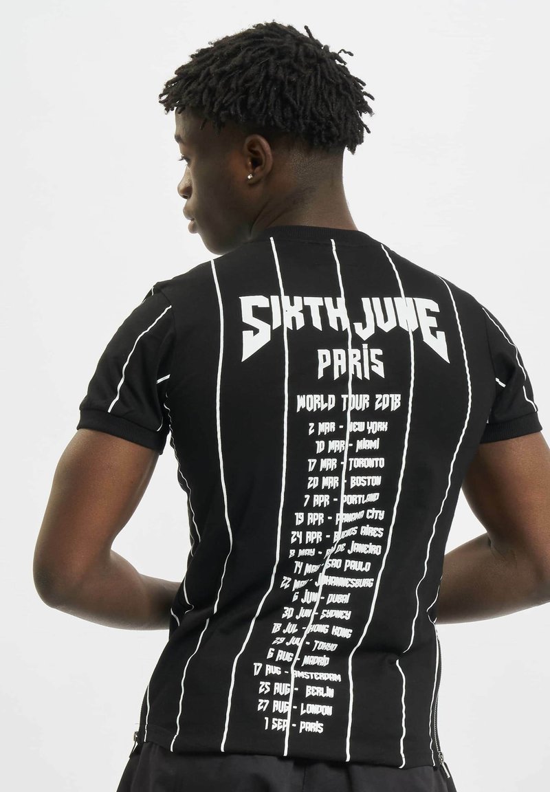 Svart T-skjorte med korte ermer og vertikale hvite striper, med "SIXTH JUNE PARIS" og en liste over konsert datoer på baksiden.