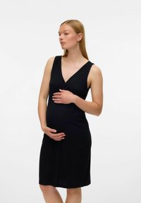 Abito premaman nero a costine con scollatura a V e design senza maniche, forma aderente che esalta il pancione, con dettaglio di bottoni sul petto.