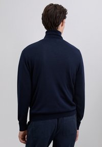 Jersey de manga larga azul marino con cuello alto y textura suave. Diseño básico sin estampados ni adornos.