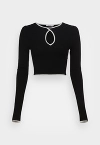Svart croppad långärmad topp med en figurnära design. Har en nyckelhålsringning med vit kant och smala ärmslut med kontrasterande detaljer. Mjuk textur.