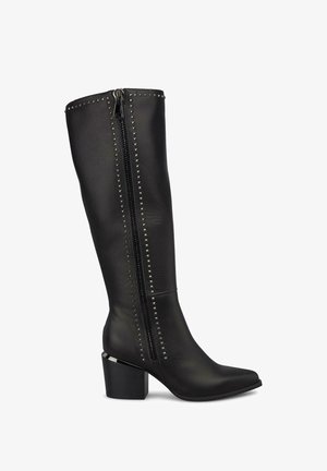 Bottes noires en cuir, montant jusqu'au genou, avec un bout pointu, des clous argentés le long de la fermeture éclair et un talon épais.