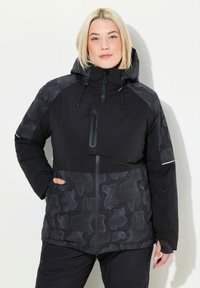 Svart vinterjacka med en texturerad, mönstrad nedre del. Har en hög krage, huva, ficka med dragkedja och justerbara snoddar.