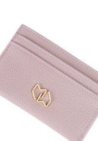 Portacarte di pelle texturizzata di colore viola chiaro con tre slot per carte. Presenta un emblema geometrico dorato sulla parte anteriore.