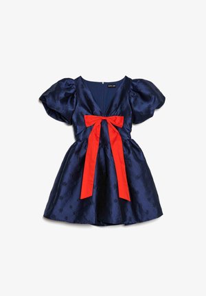 Tengerészkék szaténruha puffos ujjakkal, mély V-nyakkivágással és élénkvörös masnival a deréknál, texturált virágmintákkal díszítve.