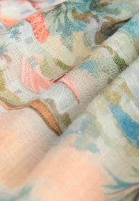 Tissu à motif floral aux couleurs pastel, présentant des dessins complexes en rose, vert et bleu avec une finition douce et texturée.