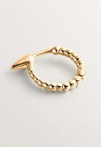 Anillo en tono dorado con forma circular, adornado con detalles de perlas y un acento puntiagudo en un lado. Textura lisa y brillante.