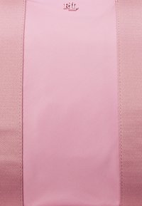 Rosa stoffpos med en jevn tekstur, med et sentralt rektangulært panel og en liten preget logo. Sømte kanter gir detalj.
