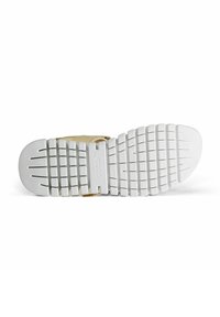 Suela de zapatilla blanca de goma con un patrón texturizado para agarre, con una ligera curva en la puntera y un soporte de correa de acento dorado.