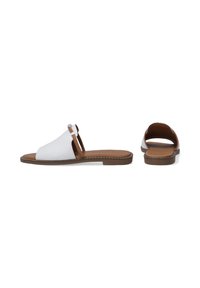 White leather slip-on sandals with brown accents, a flat sole, and subtle stitching detail along the edge. Open back design.