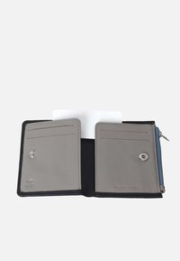 Portafoglio protetto da RFID con interno in vera pelle grigia, dotato di scomparti per carte, tasca con zip e chiusura a scatto. Esterno nero texture.