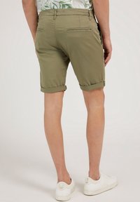 Bermudas verde oliva con corte recto, dobladillos con vuelta y dos bolsillos traseros. Fabricadas con un tejido ligero, diseñadas para el uso casual.