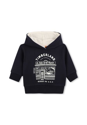 Sweat à capuche bleu marine pour tout-petit avec doublure beige, graphique du magasin Timberland et texte imprimé "Timberland New Hampshire" en blanc.