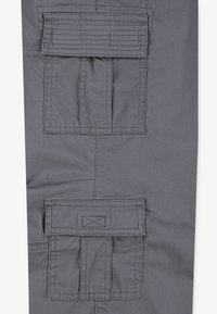Gray fabric with two square cargo pockets, each featuring a flap secured by horizontal stitching and rectangular reinforced seams.