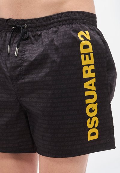 Μαύρα μαγιό σορτς με επαναλαμβανόμενο μοτίβο "DSQUARED2" σε τονικό χρώμα, με έντονο κίτρινο λογότυπο στο αριστερό μέρος και ελαστική μέση.
