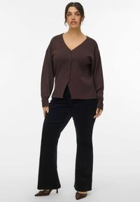 Cardigan marrone con bottoni, scollatura a V e vestibilità rilassata, abbinato a pantaloni neri a gamba larga e tacchi. Tessuto liscio, design casual.